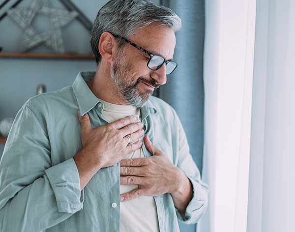 heartburn, gerd, man holding chest, uncomfortable