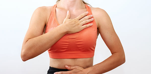 Female person doing yoga breathing exercise, hands on chest and belly. Wellness and meditation