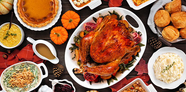 Traditional Thanksgiving turkey dinner table scene on a rustic dark wood background stock photo