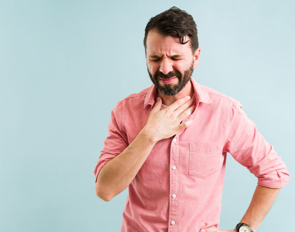 uffering from a sore throat isolated against a background. Latin man with a reflux because of a heavy meal or dinner. gerd